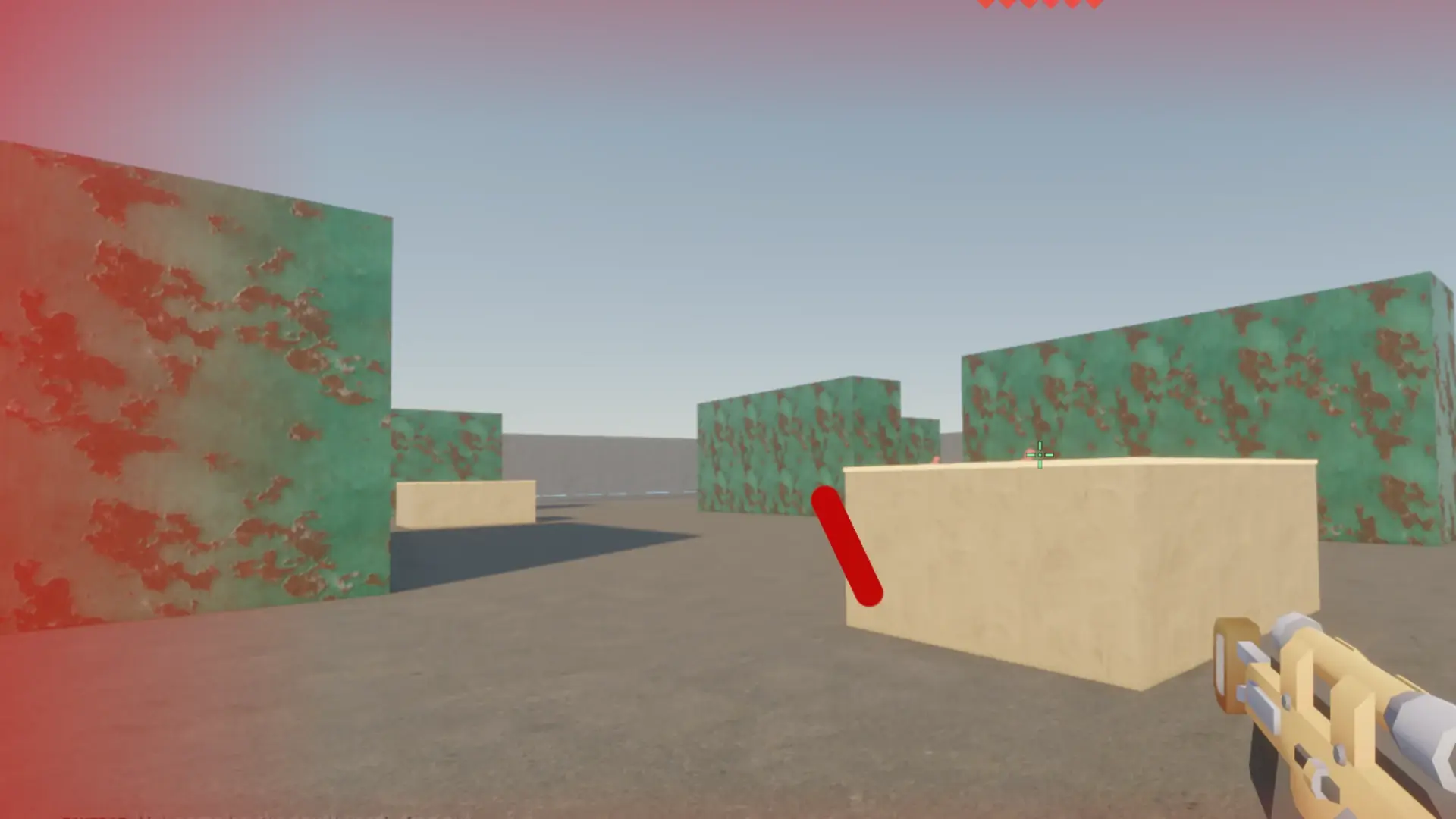 Foundry under fire: a red tracer crosses a sand-coloured crate and the screen edges glow red with damage.